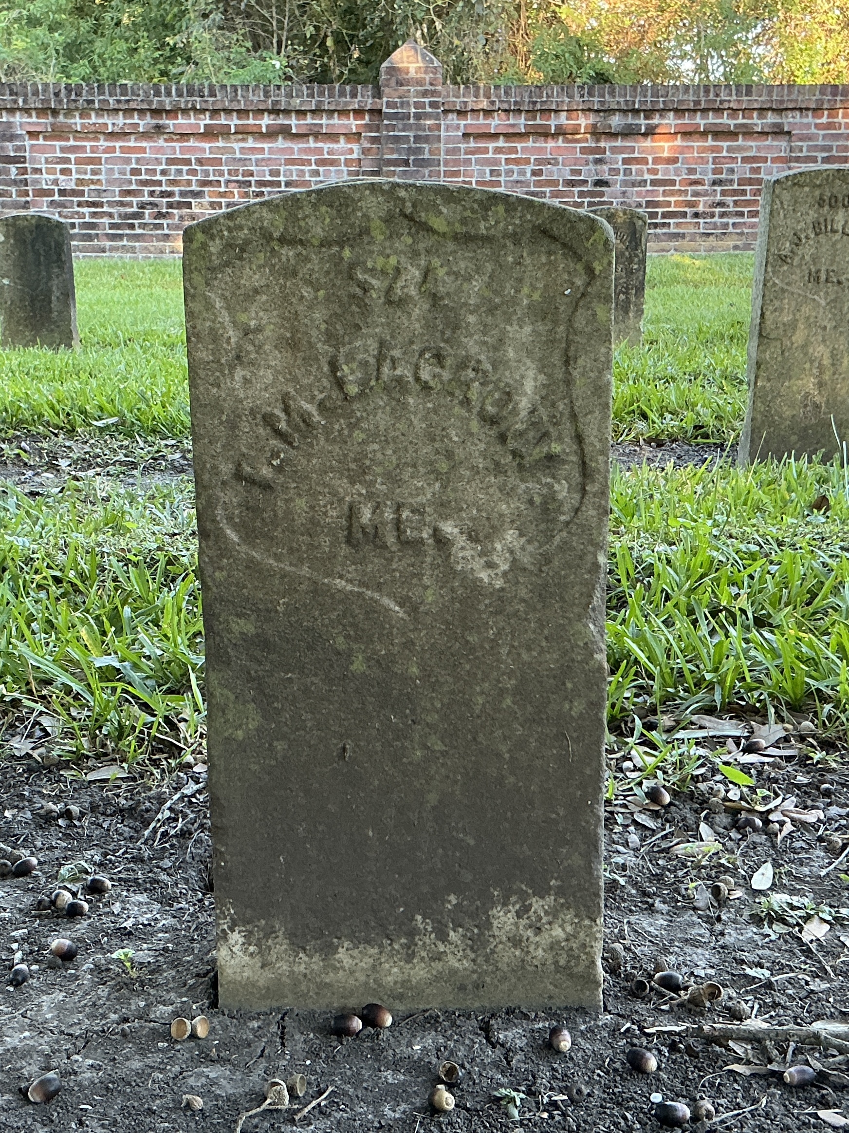 Front of historic upright marble headstone with recessed shield face.