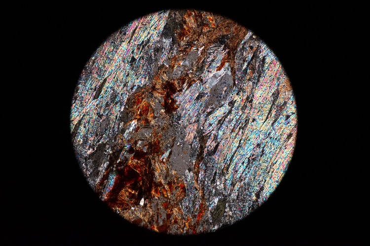 Circular microscopic image of rock structure.