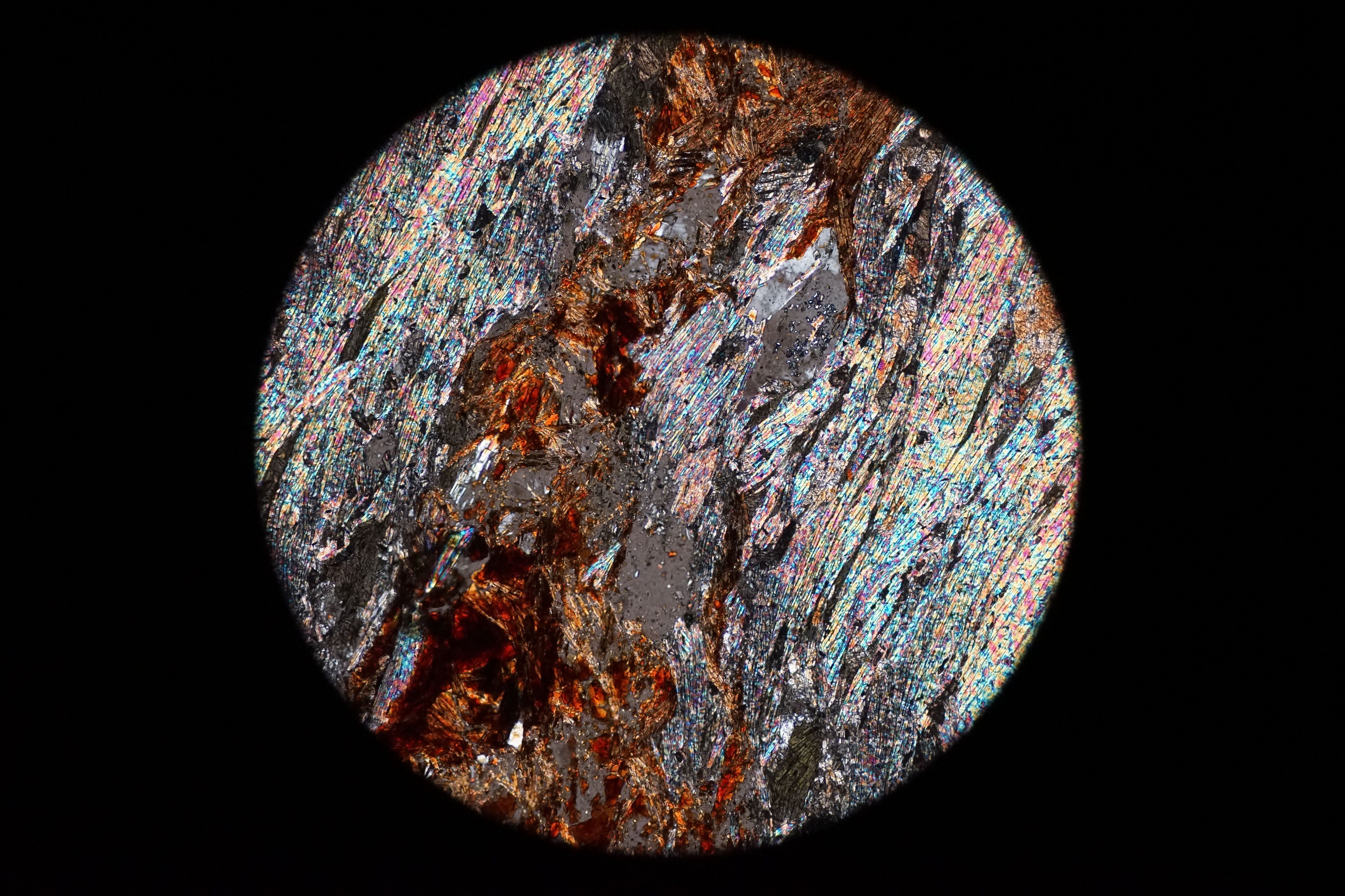 Circular microscopic image of rock structure.