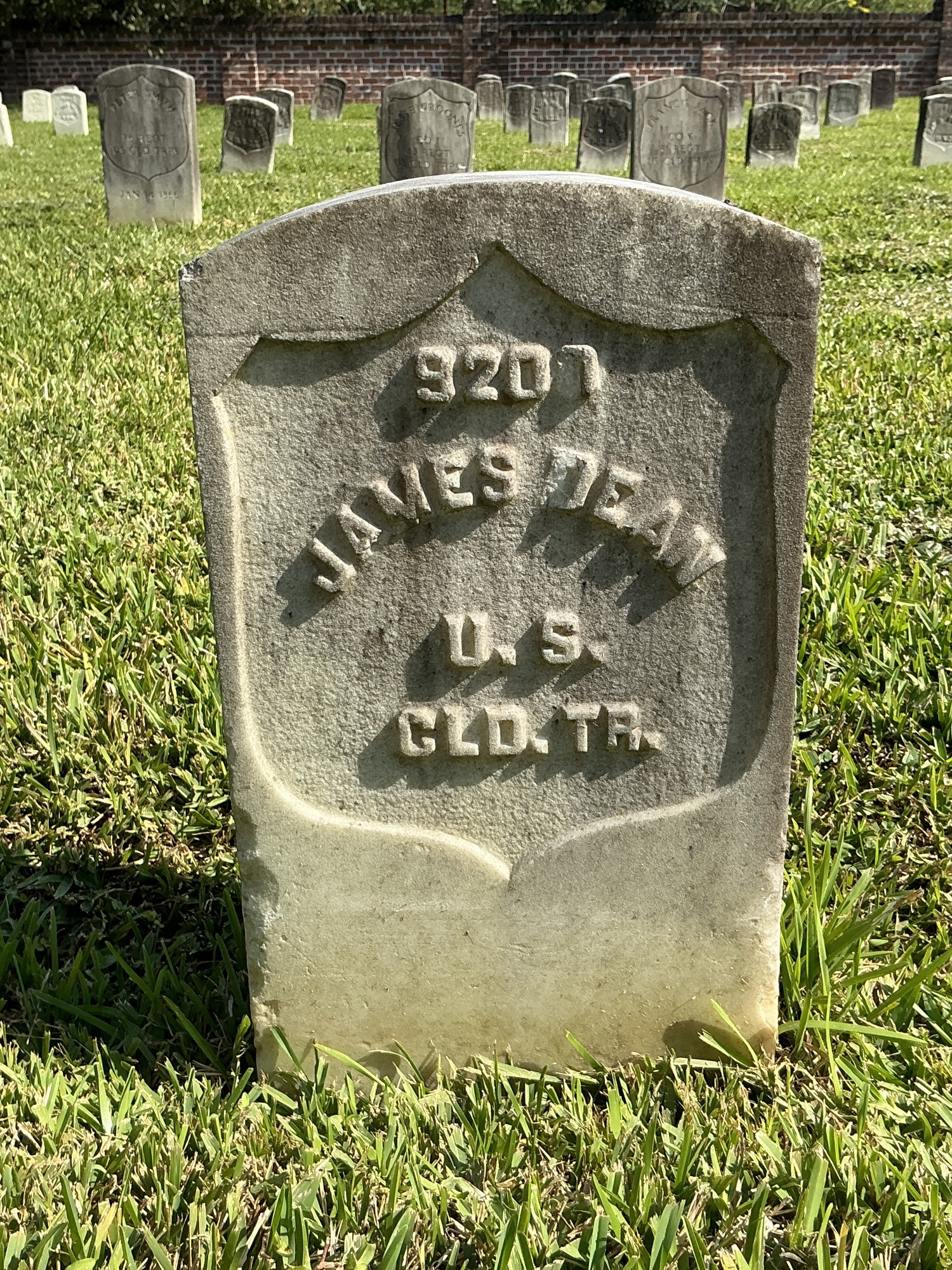 Front of historic upright marble headstone with recessed shield face.