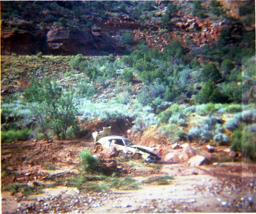 Color photos of park personnel removing a car from the flood waters of the 1975 flood.
