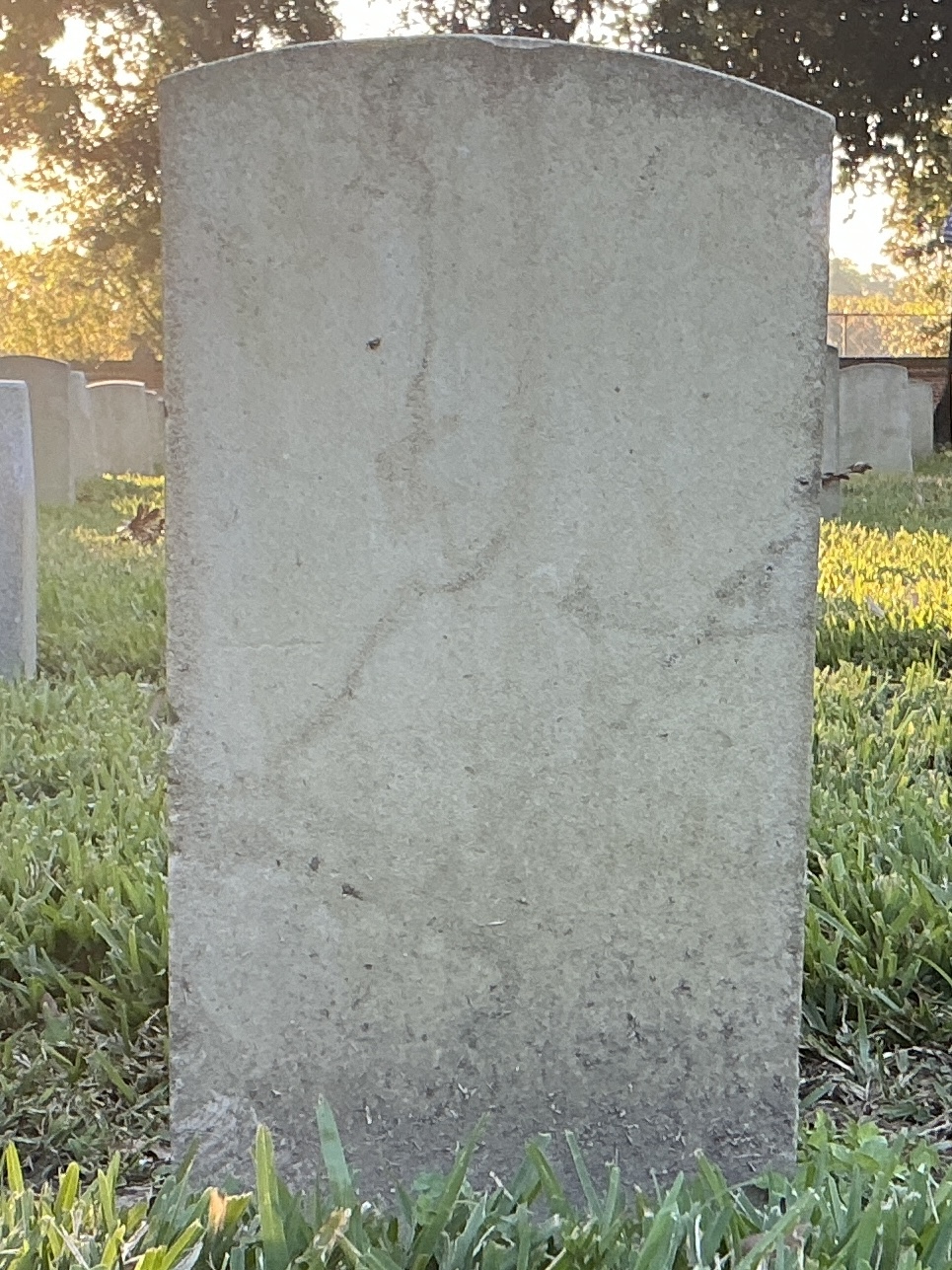 Back of historic upright marble headstone with recessed shield face.