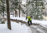 Maintenance worker shoveling snow from a trail near a river