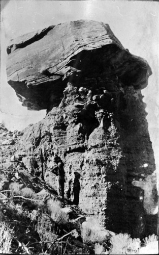 W. L. Crawford (father of J.L. Crawford) standing next to Chimney Rock, across river from south end of Springdale.