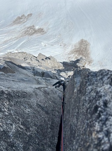 A ranger climbs up a rock face