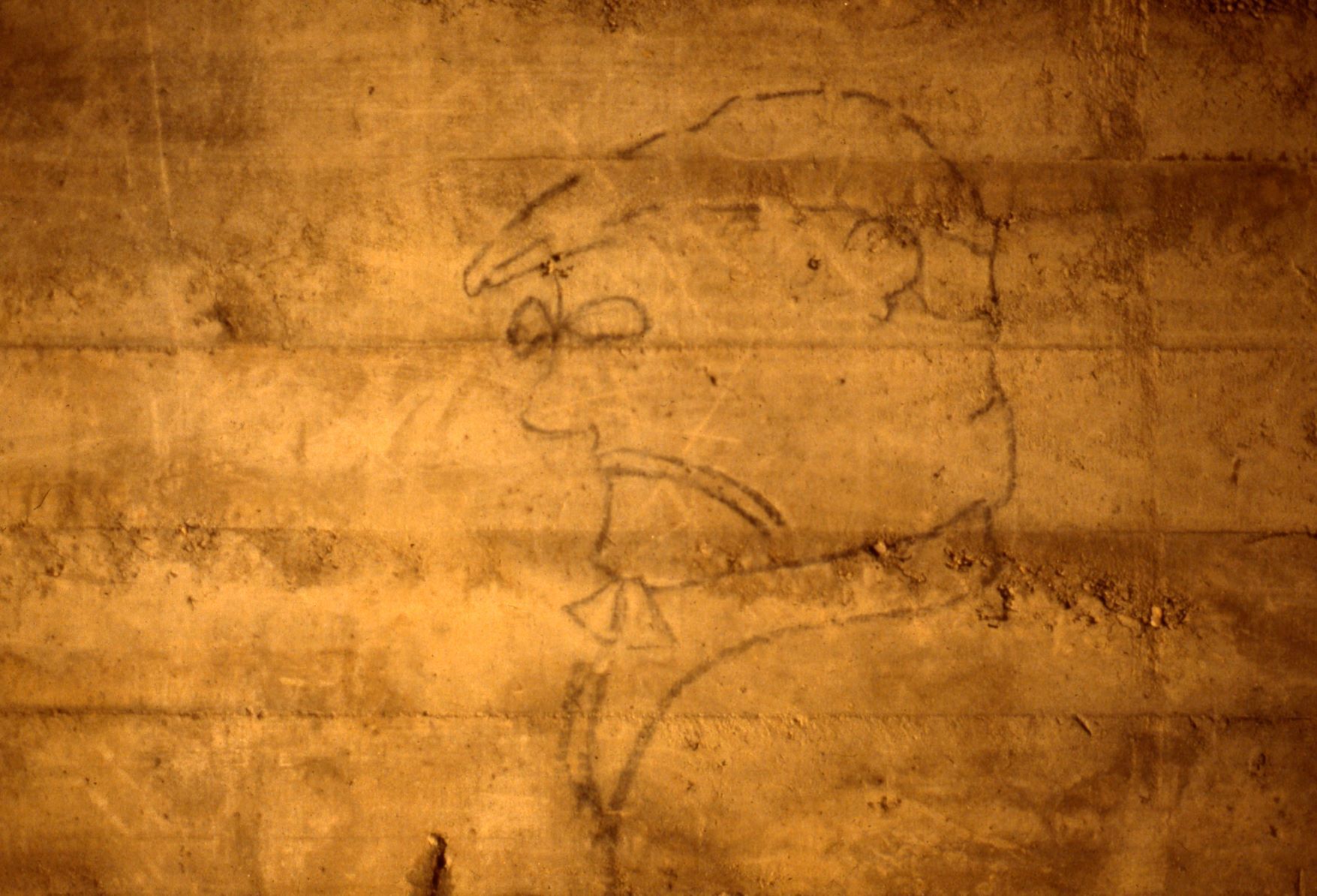 Graffiti of a caricature of a man wearing glasses and a cap.