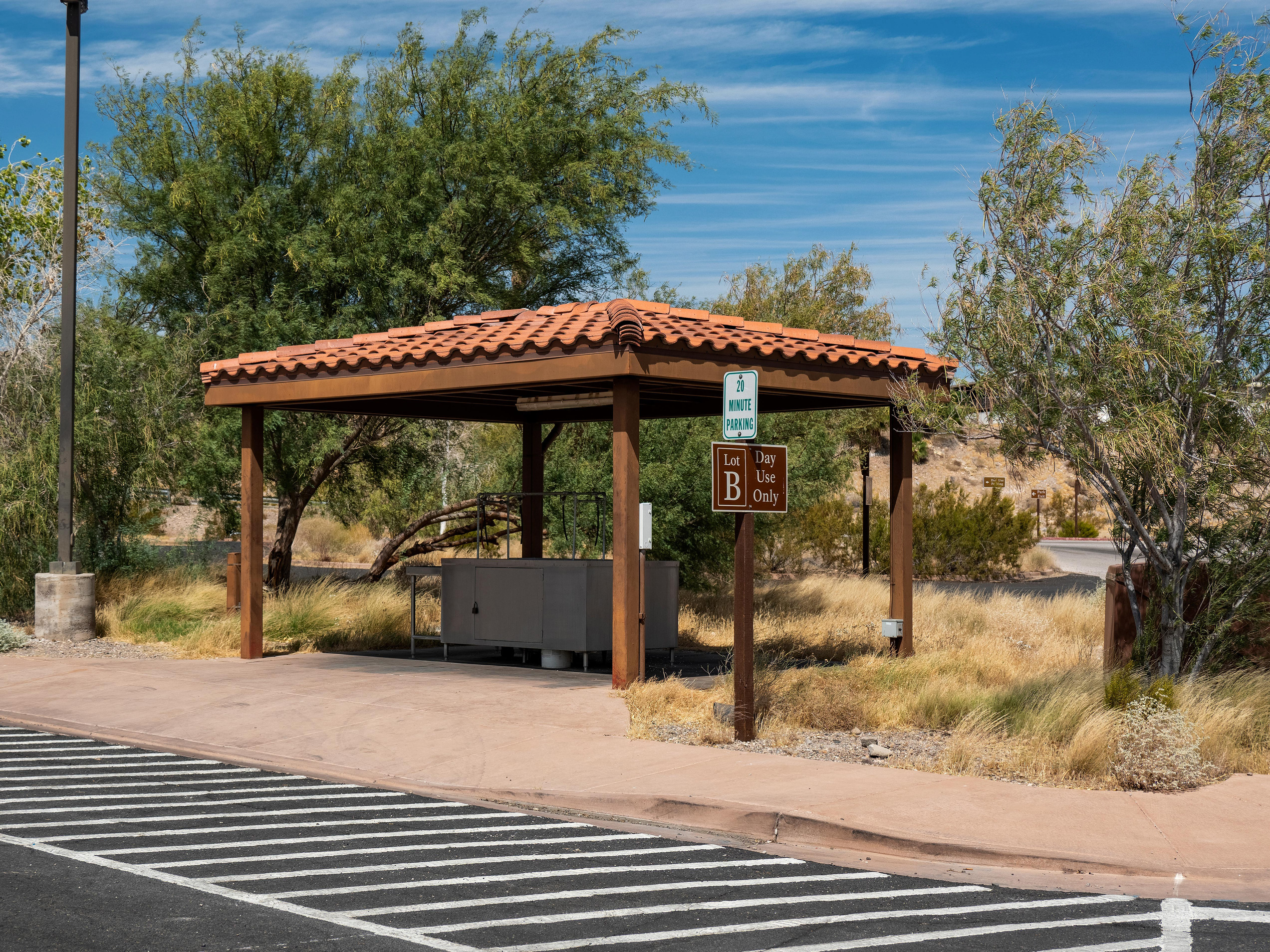 Fish cleaner under wooden shade structure. Handicap parking area in foreground