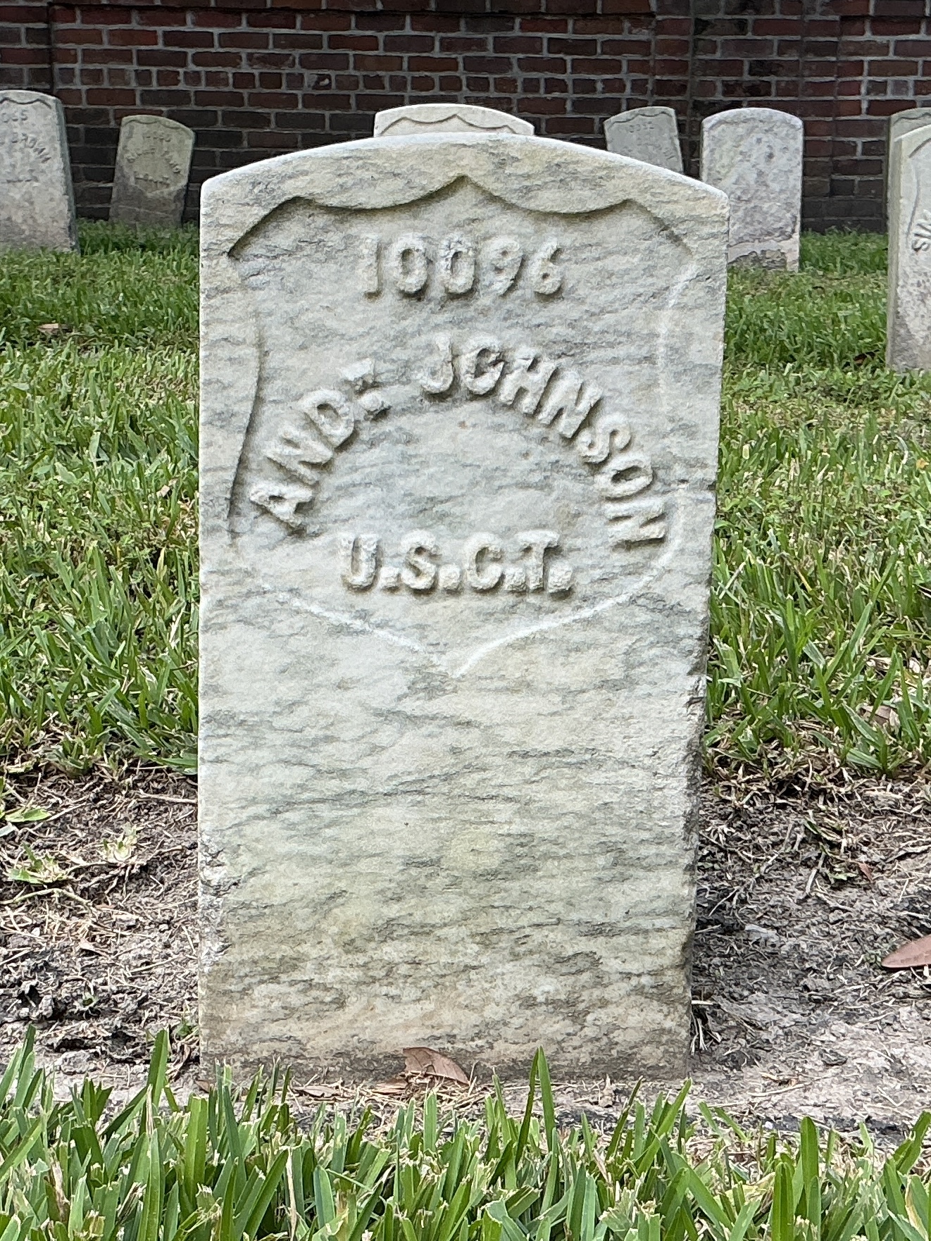 Front of historic upright marble headstone with recessed shield face.