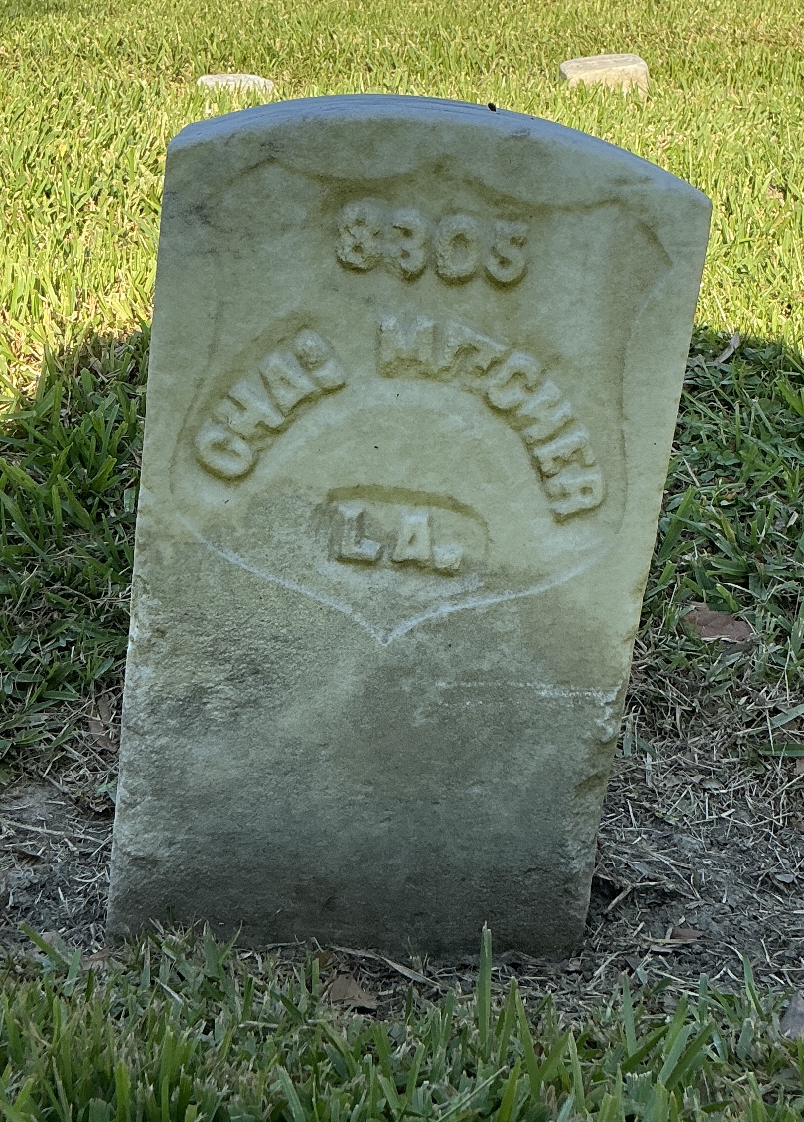 Front of historic upright marble headstone with recessed shield face.