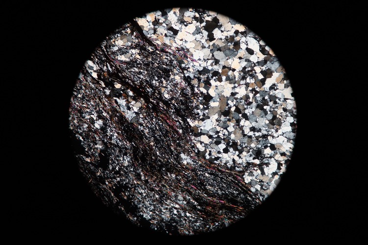 Circular microscopic image of rock structure.