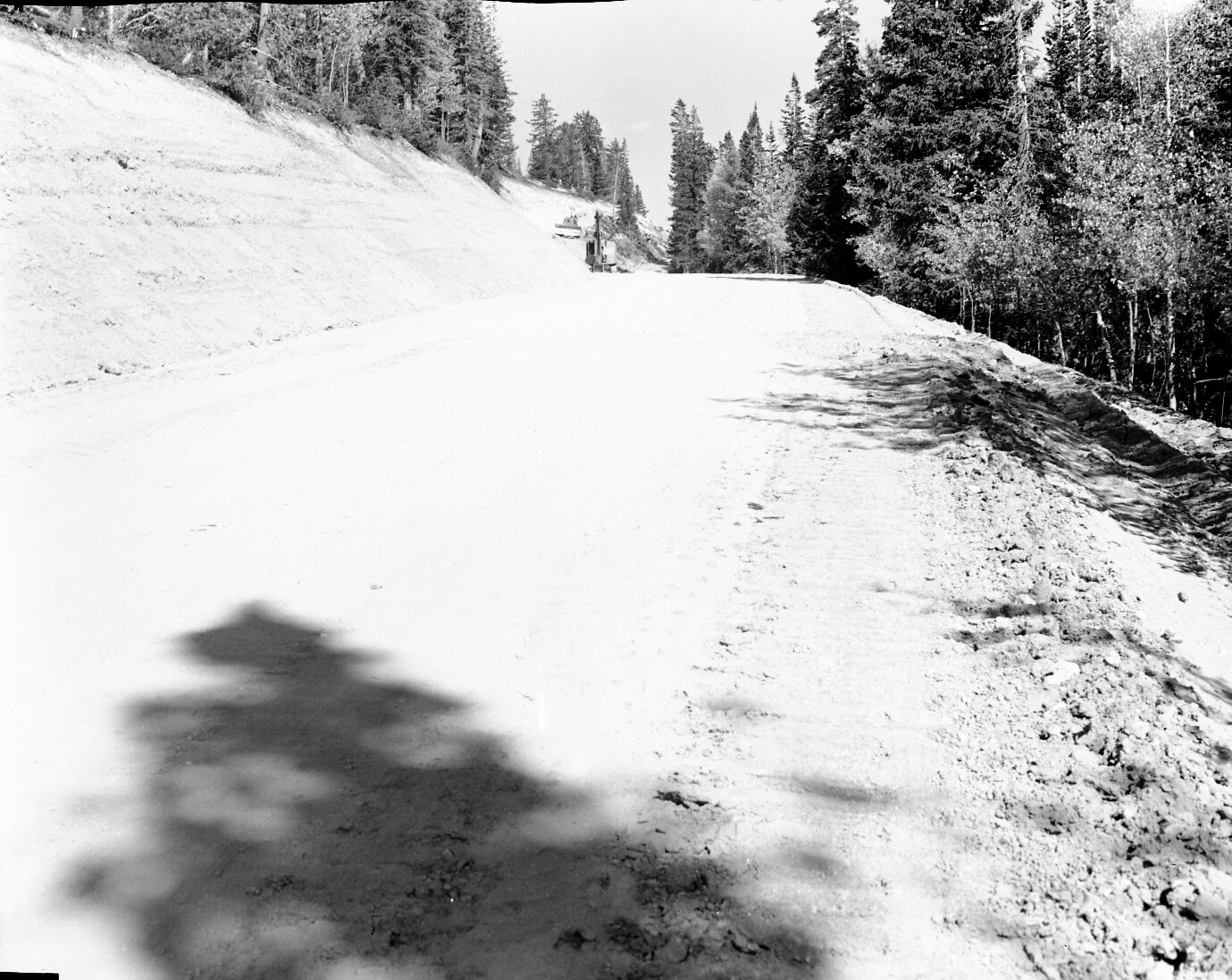 Road construction work on Dugway Hill, bulldozer and backhoe equipment in background.