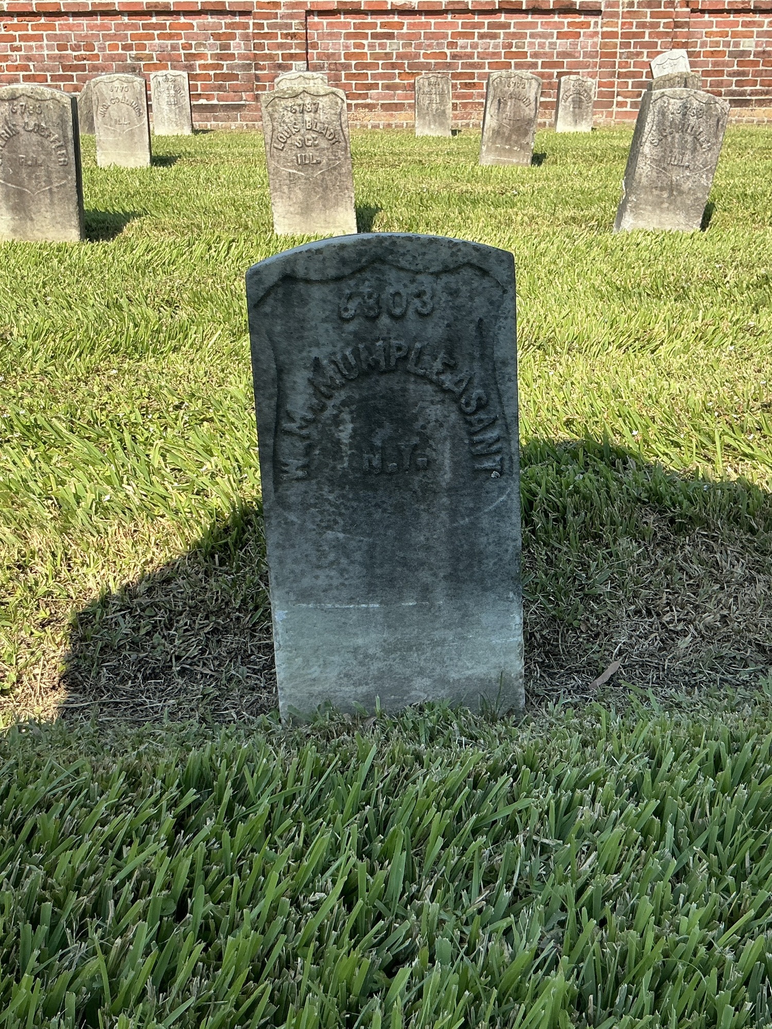 Front of historic upright marble headstone with recessed shield face.