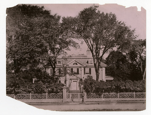 Georgian mansion from across the street framed by two tall trees