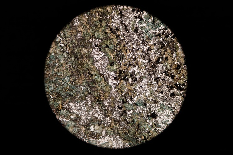 Circular microscopic image of rock structure.