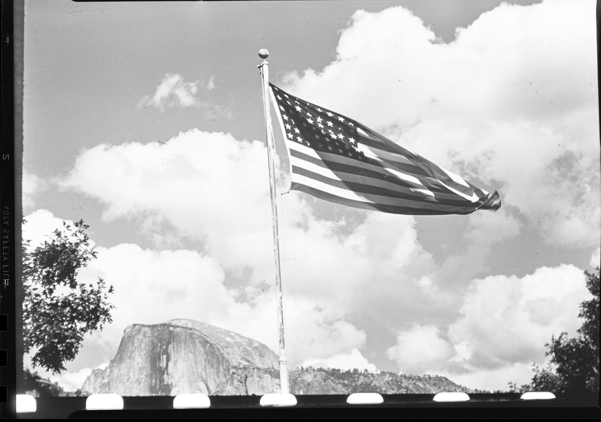 Flag flying with Half Dome in background.