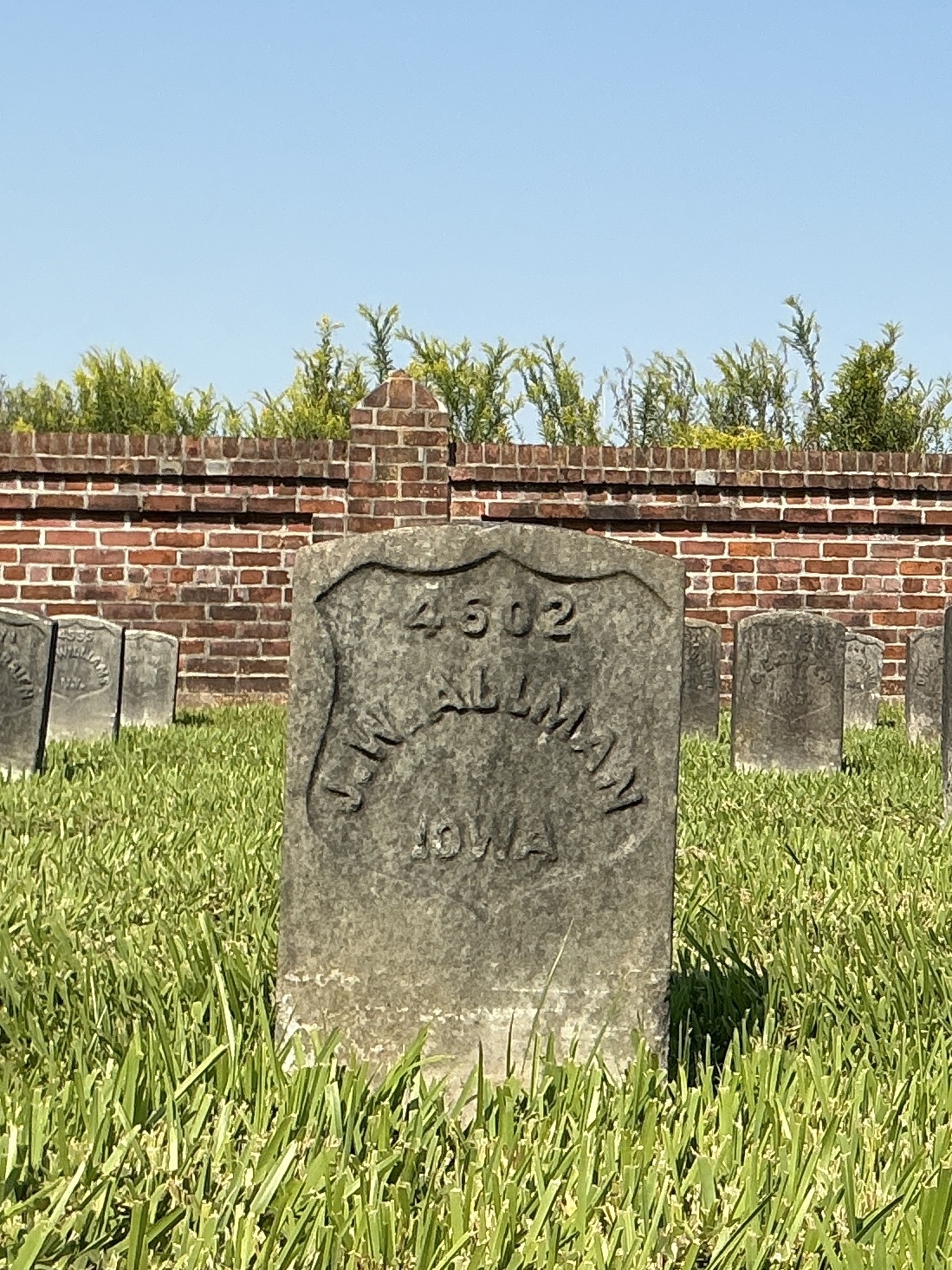 Front of historic upright marble headstone with recessed shield face.