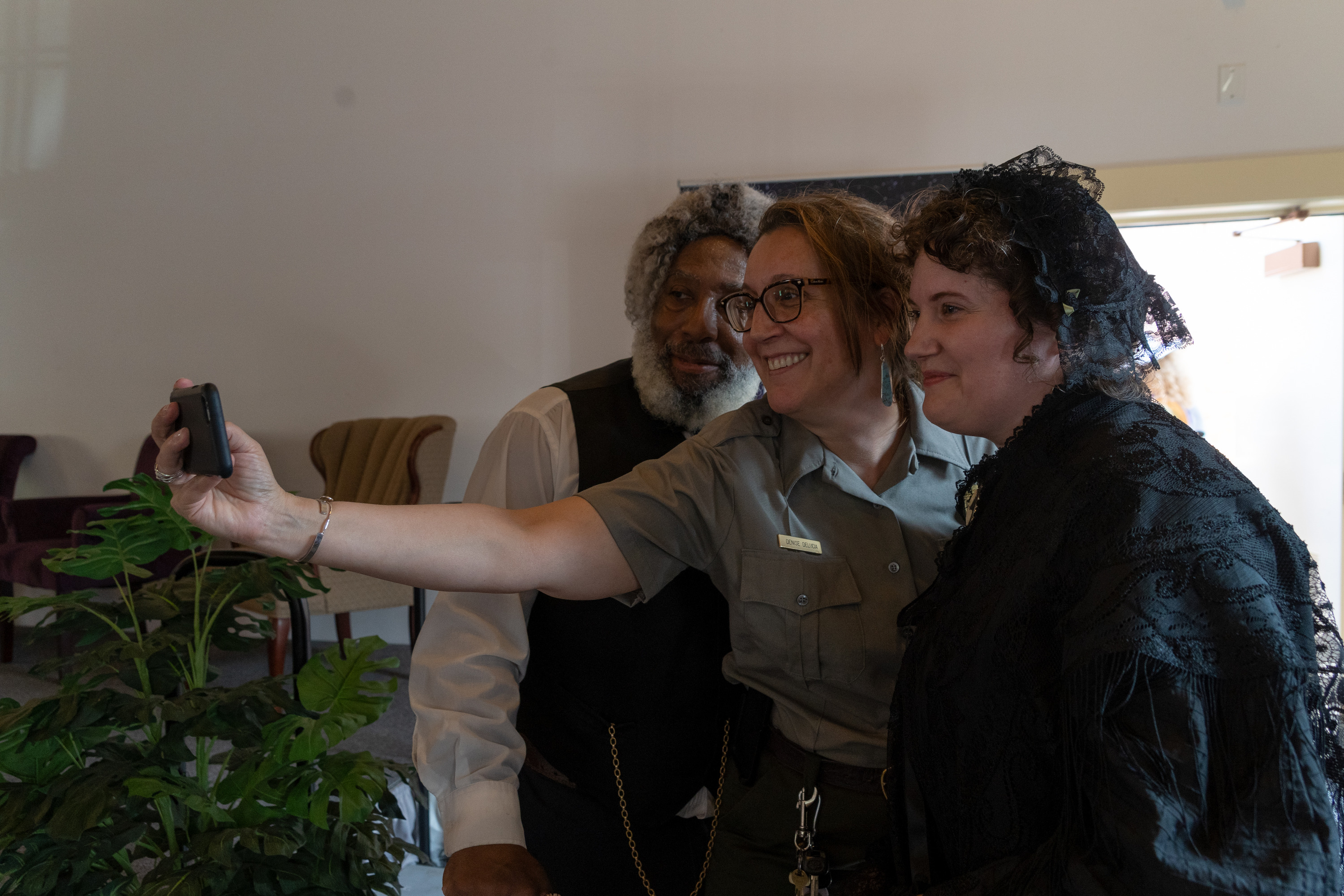 A Park Ranger, Elizabeth Cady Stanton, and Frederick Douglass take a picture together. 
