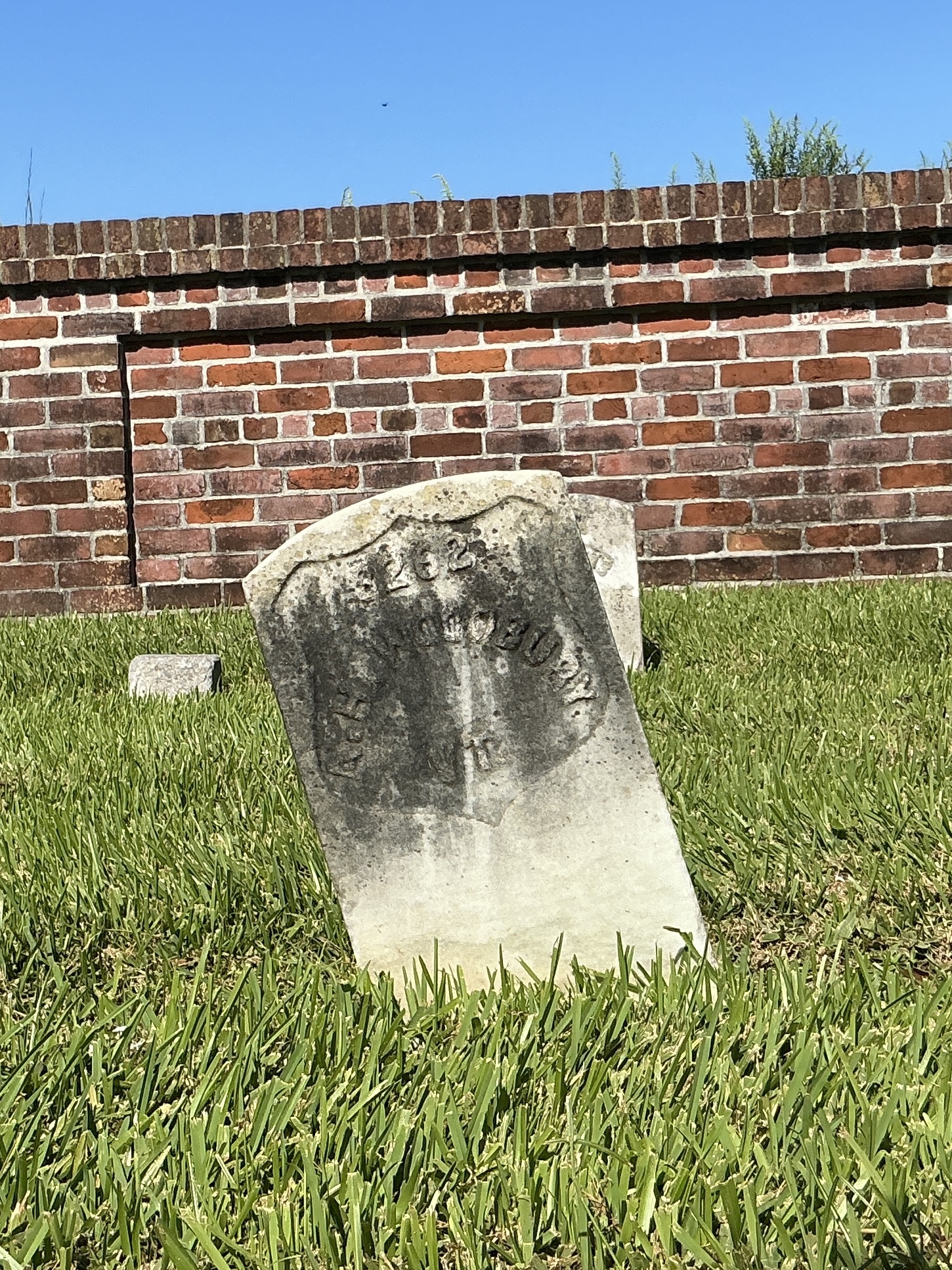 Front of historic upright marble headstone with recessed shield face.