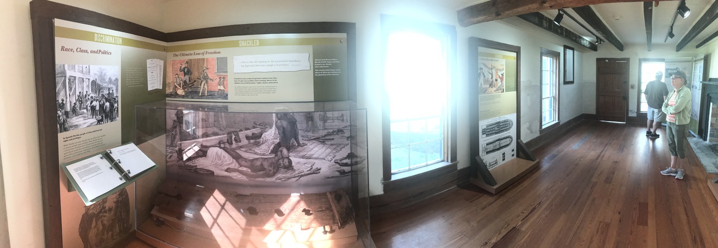 exhibit panels on slavery being read by visitors.