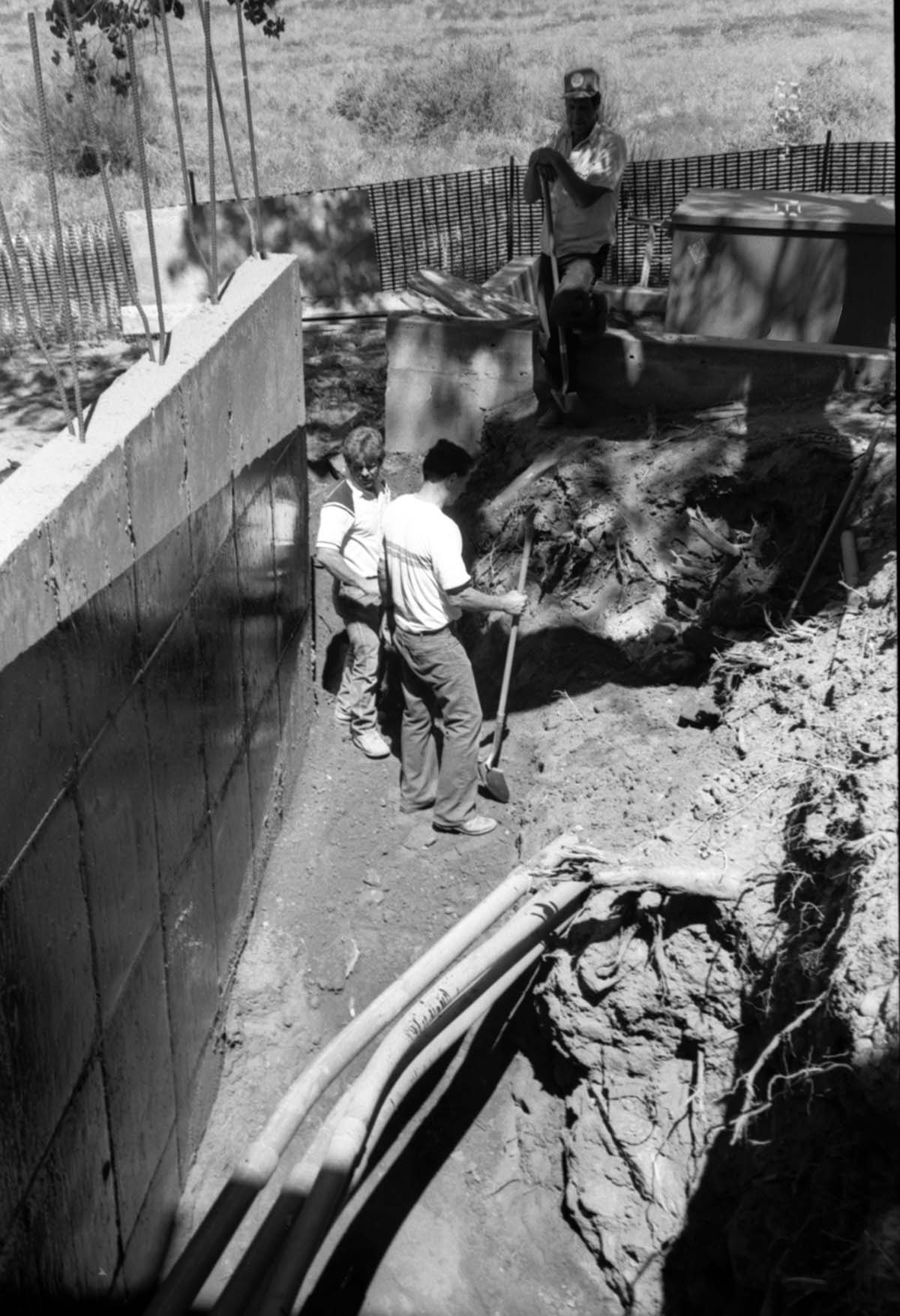 Men working with shovels during construction of headquarters addition.