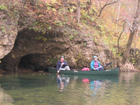 Canoing near a water level cave on the Current River.