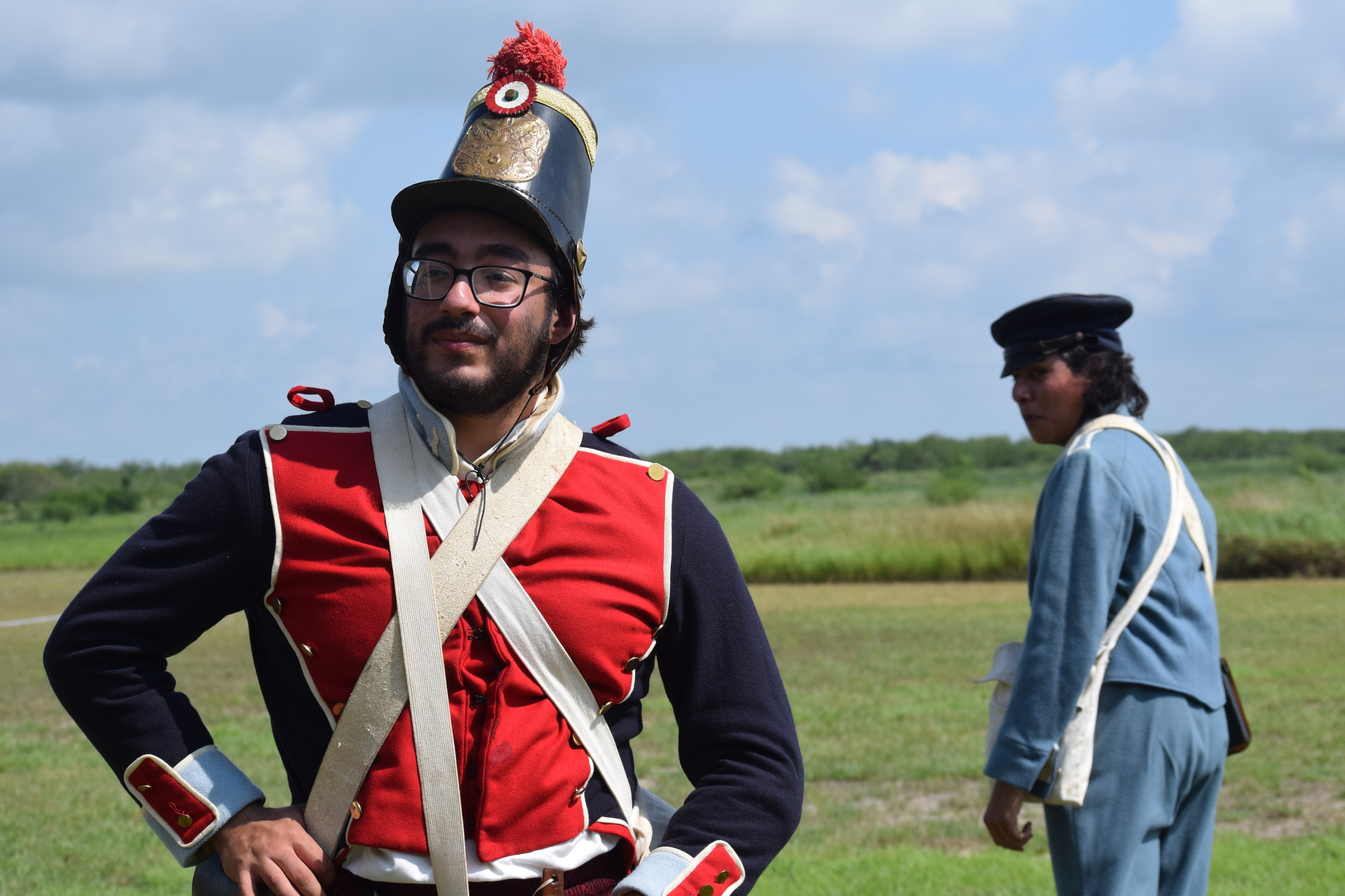 Mexican Infantry soldier flaunts uniform while US infantry soldier looks back at him.