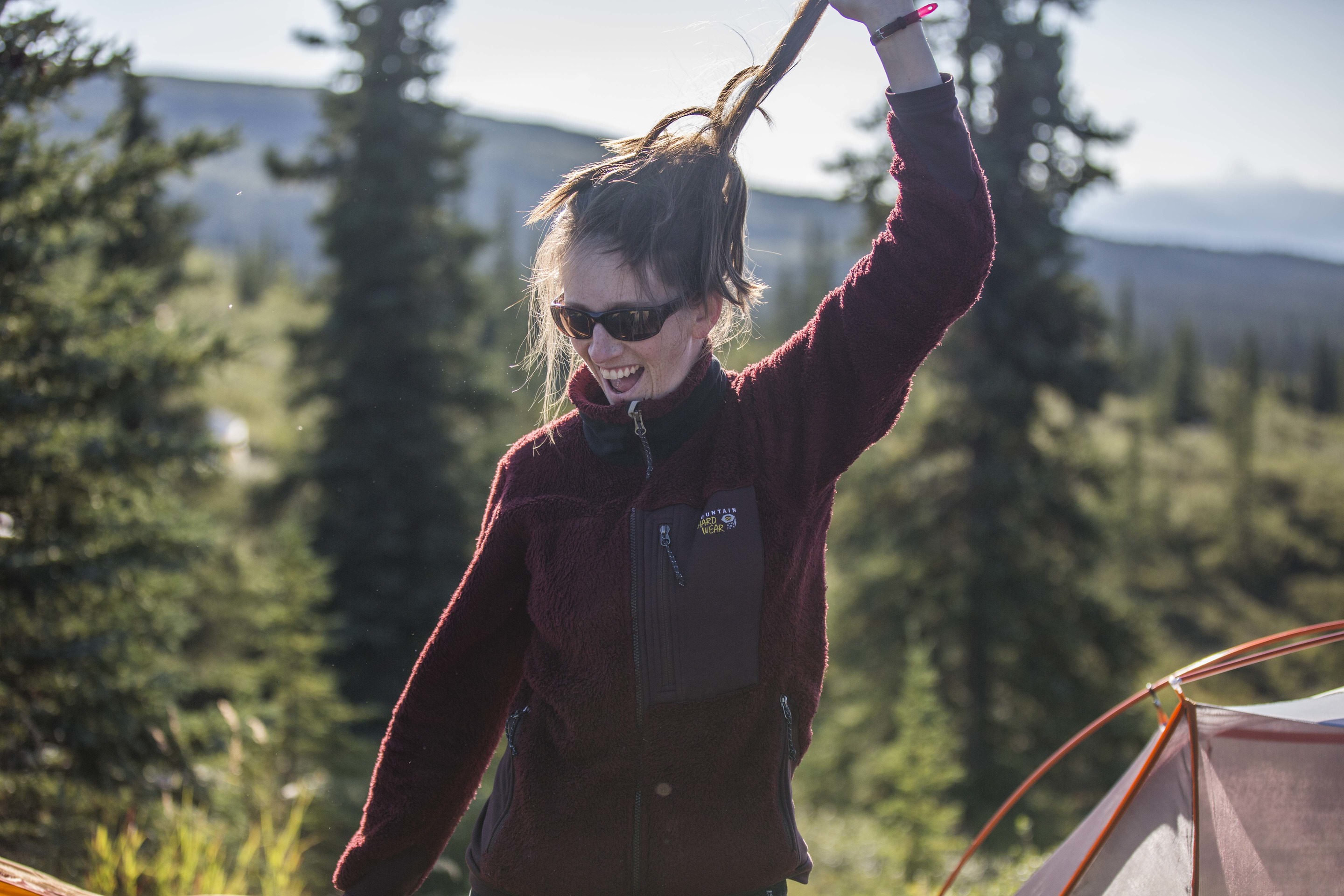 a woman smiling near a tent