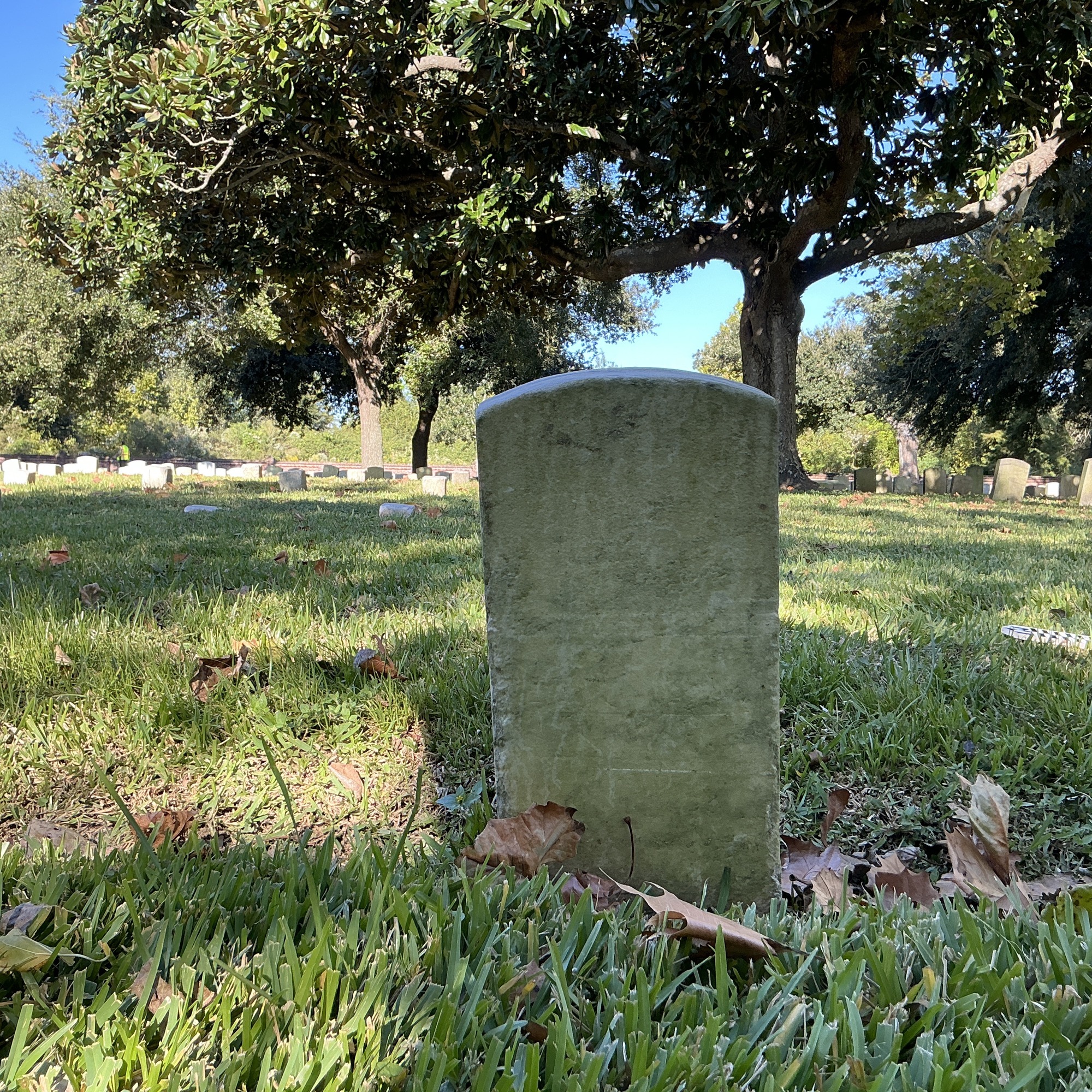 Back of historic upright marble headstone with recessed shield face.