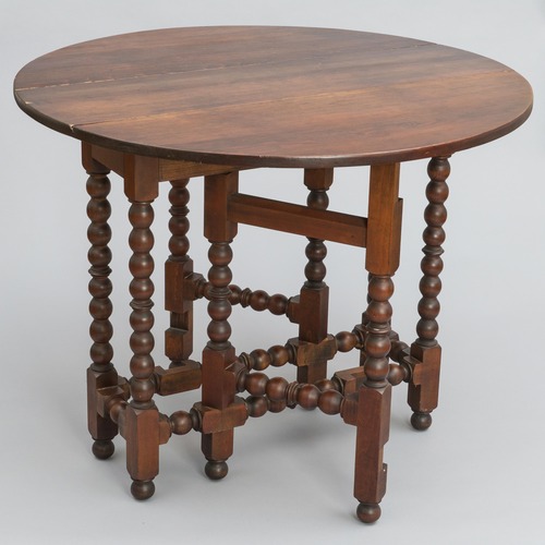 A wood table with round top and spool-turned legs.