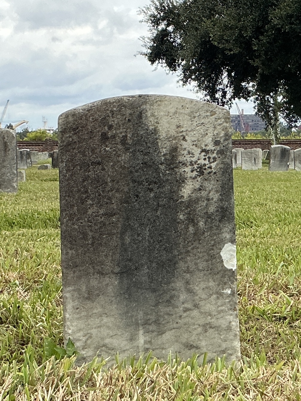 Back of historic upright marble headstone with recessed shield face.