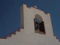 A white building with a bell on top.