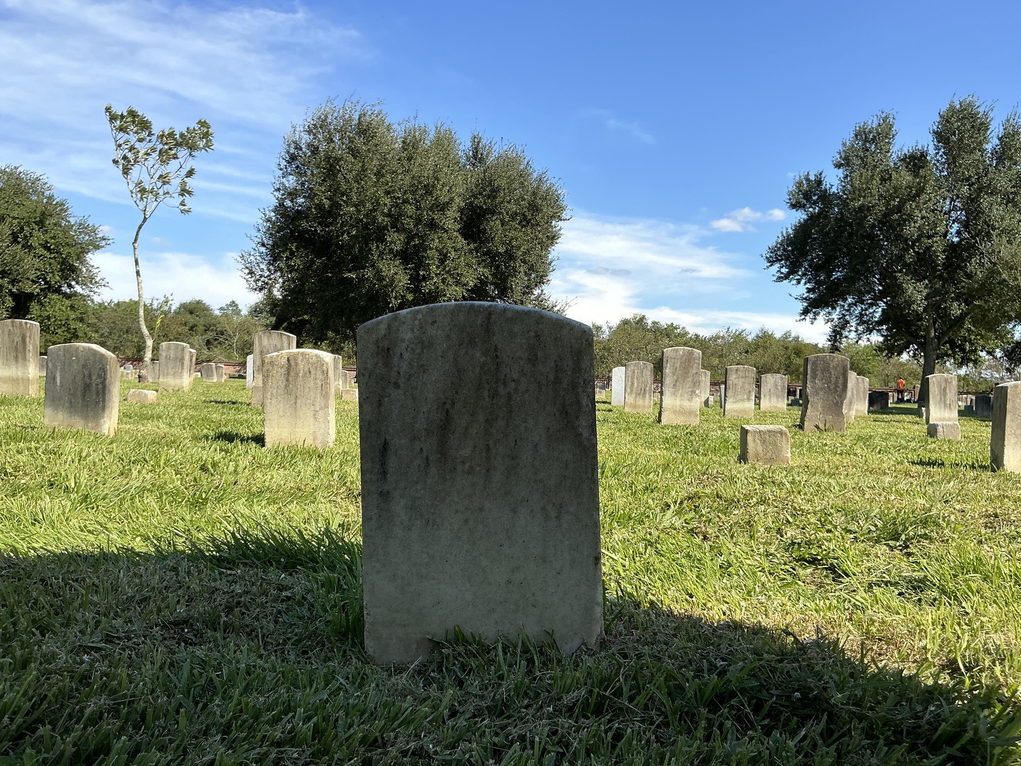 Back of historic upright marble headstone with recessed shield face.