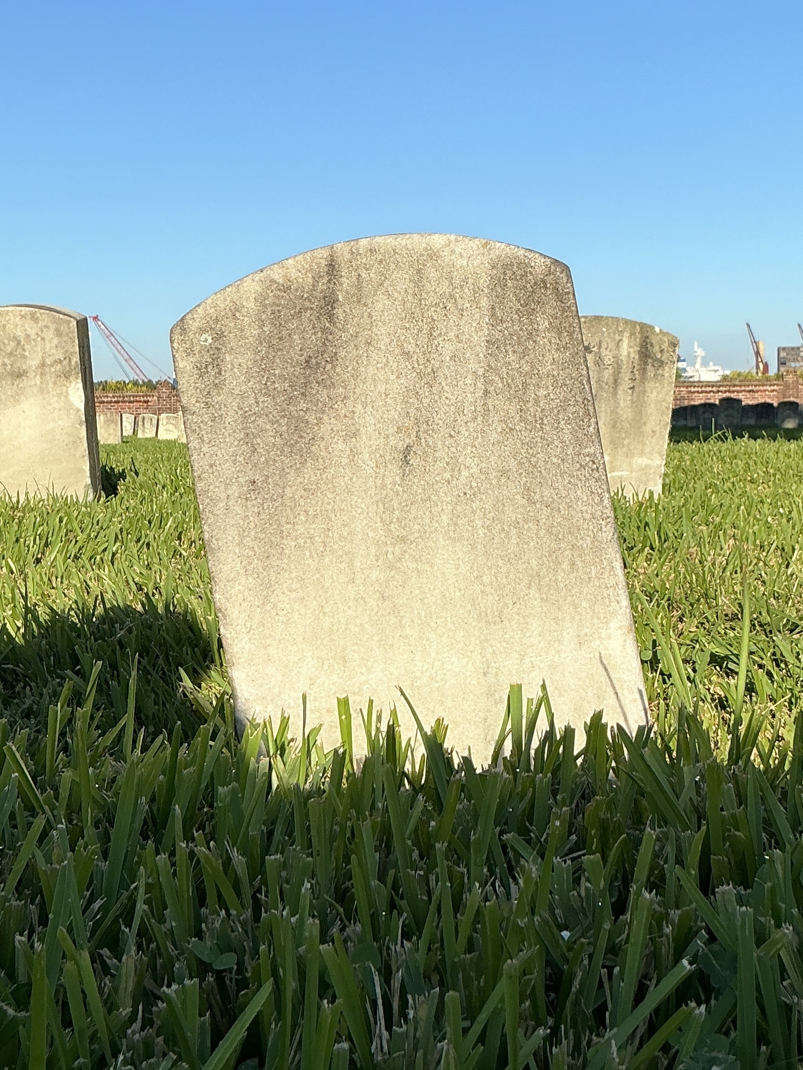Back of historic upright marble headstone with recessed shield face.