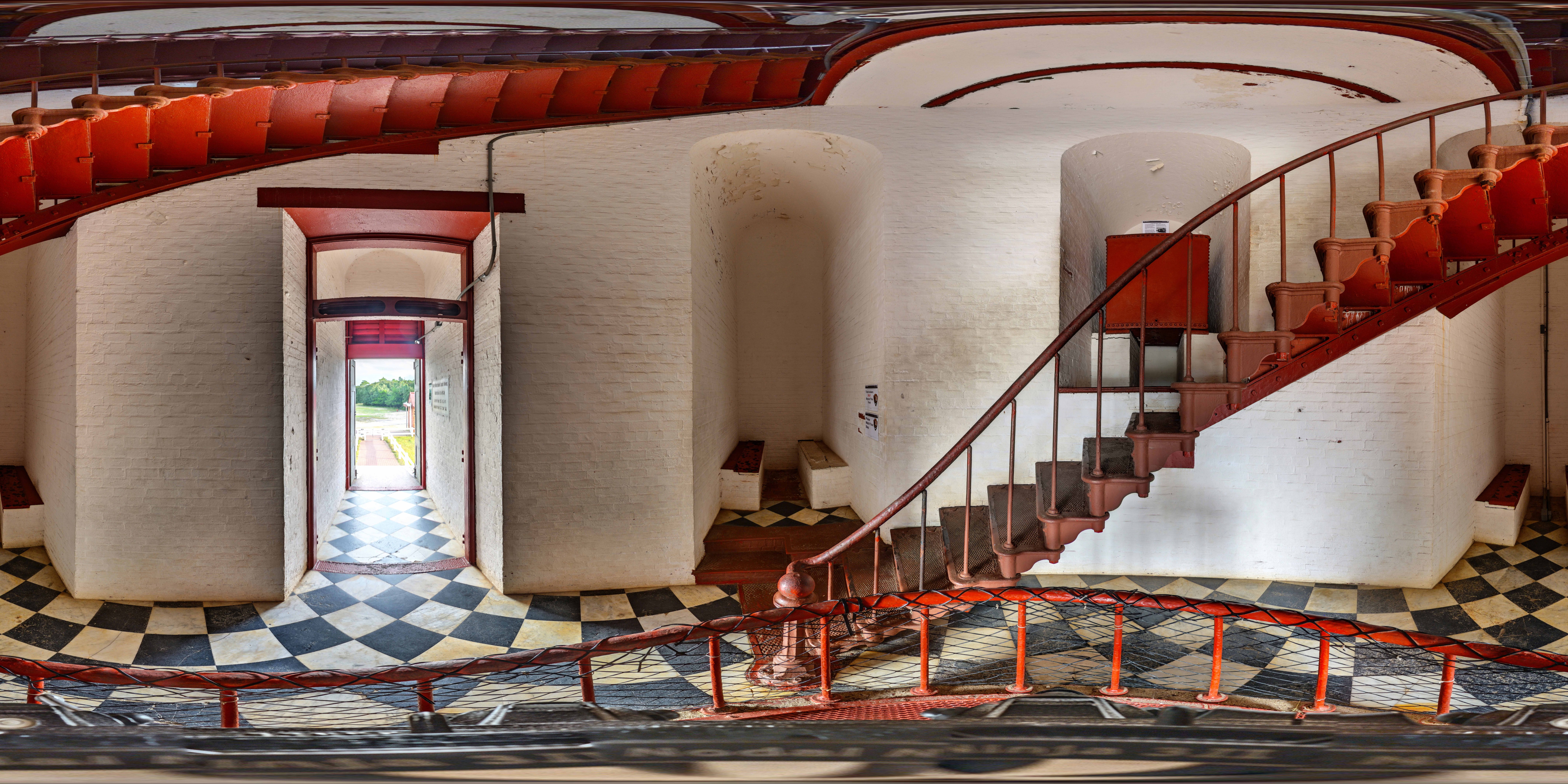 Panoramic photograph of the ground level of red staircase in lighthouse