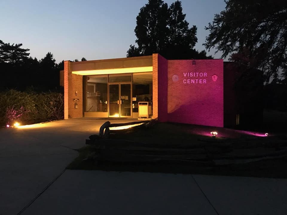 Visitor center lit purple and gold at night