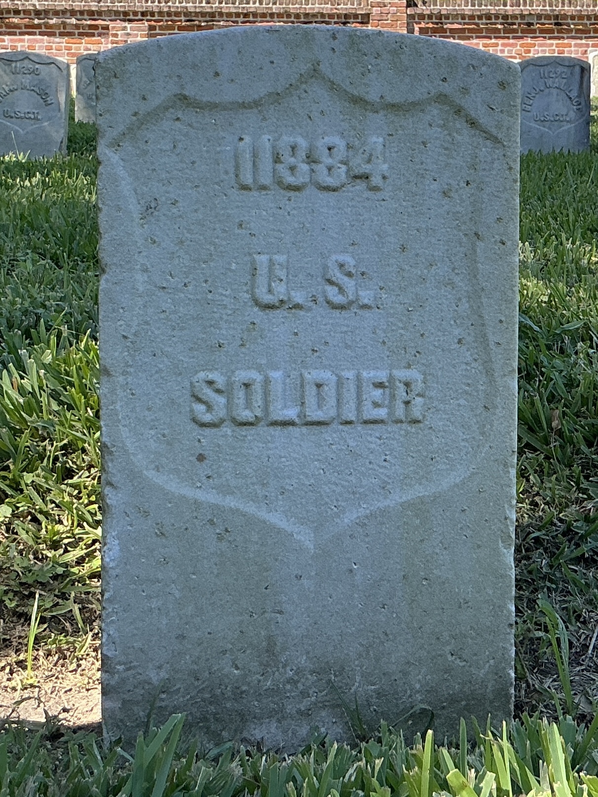 Front of historic upright marble headstone with recessed shield face.