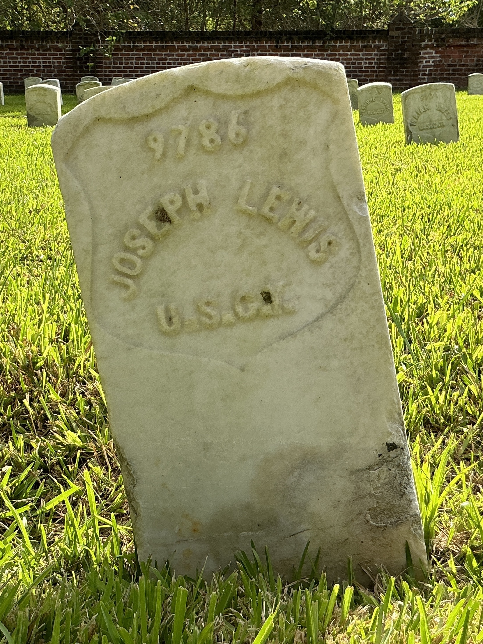 Front of historic upright marble headstone with recessed shield face.