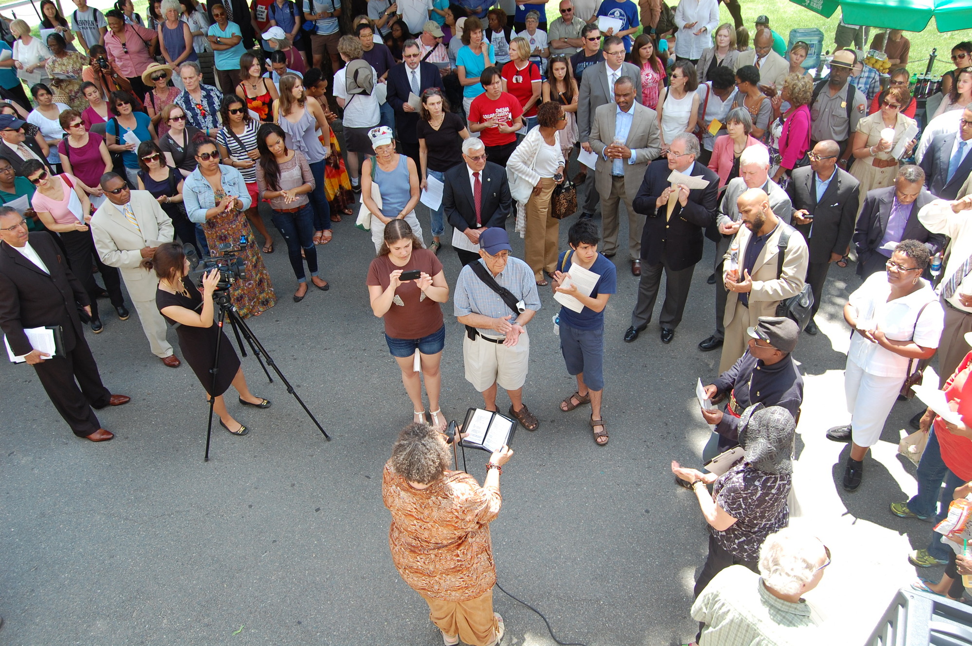 Aerial view of people standing around a speaker. 