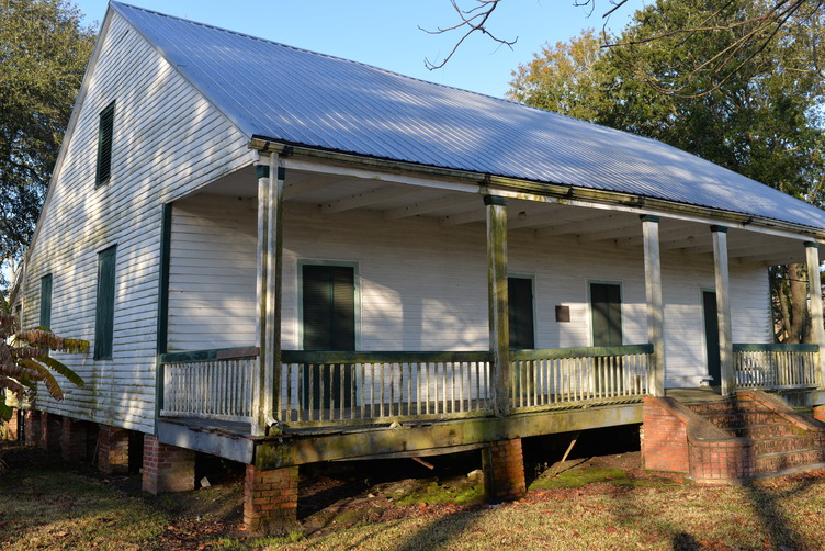 White sided structure with green accents.