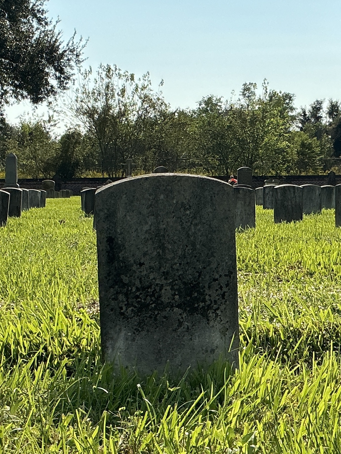 Back of historic upright marble headstone with recessed shield face.