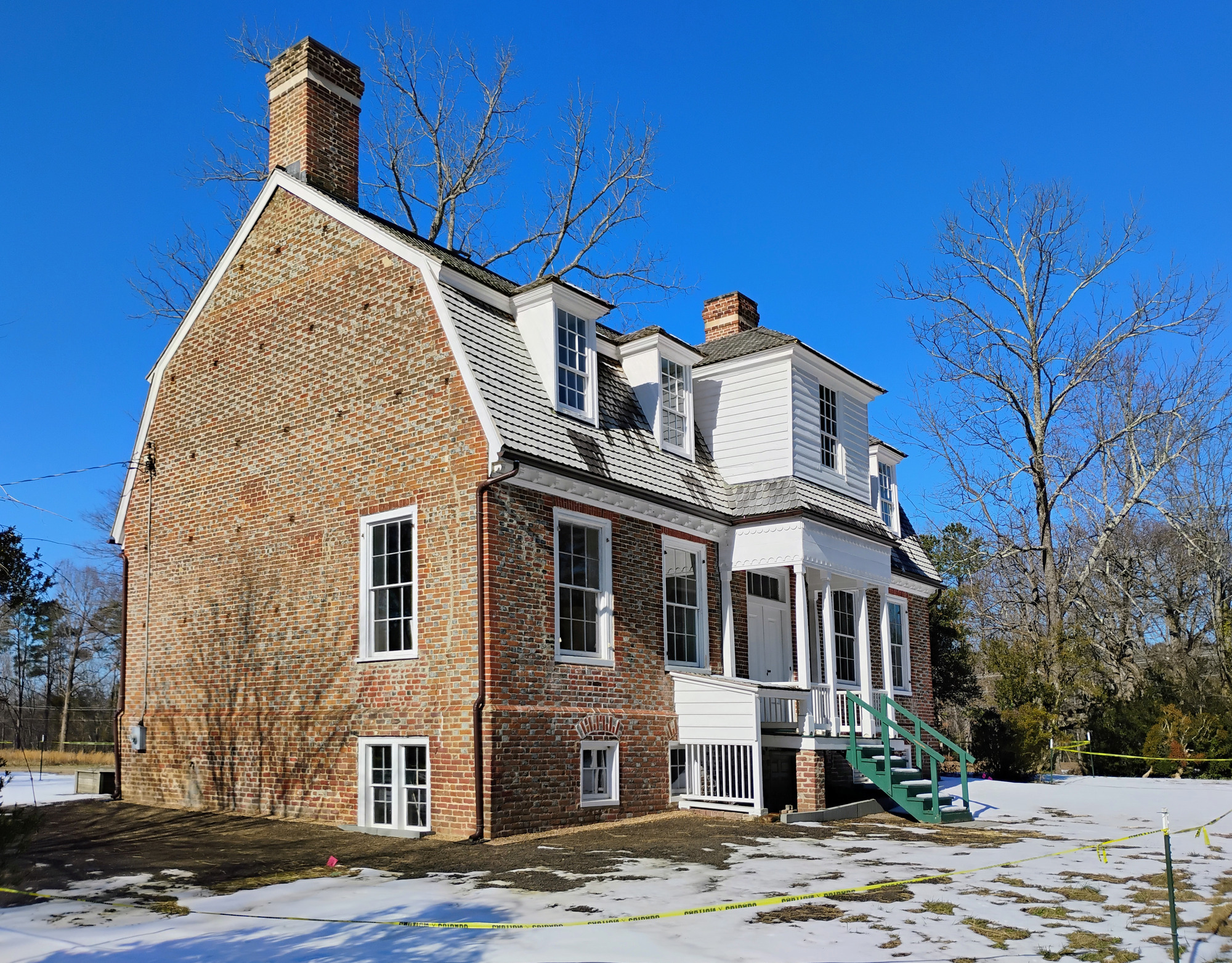 Angled view of the front of the Shelton House in winter with snow on the ground.