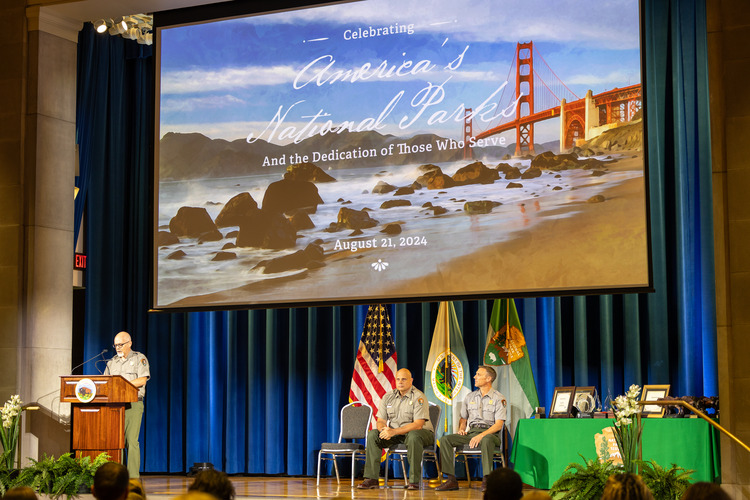 A man speaks at a podium at an awards ceremony.