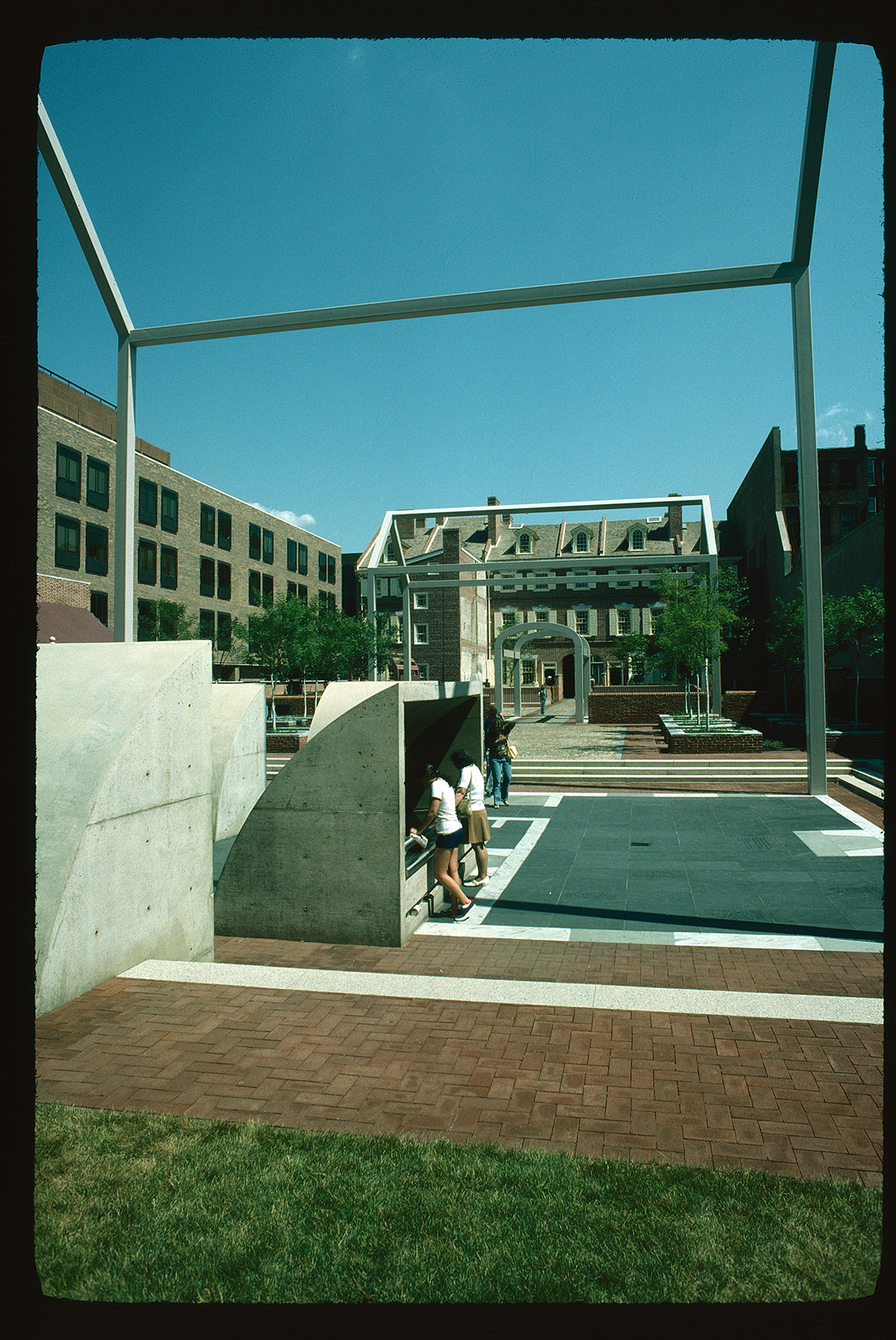Franklin Court. Looking north from behind ghost structure of Franklin's house, towards Market Street. Visitors looking through window at original foundation.