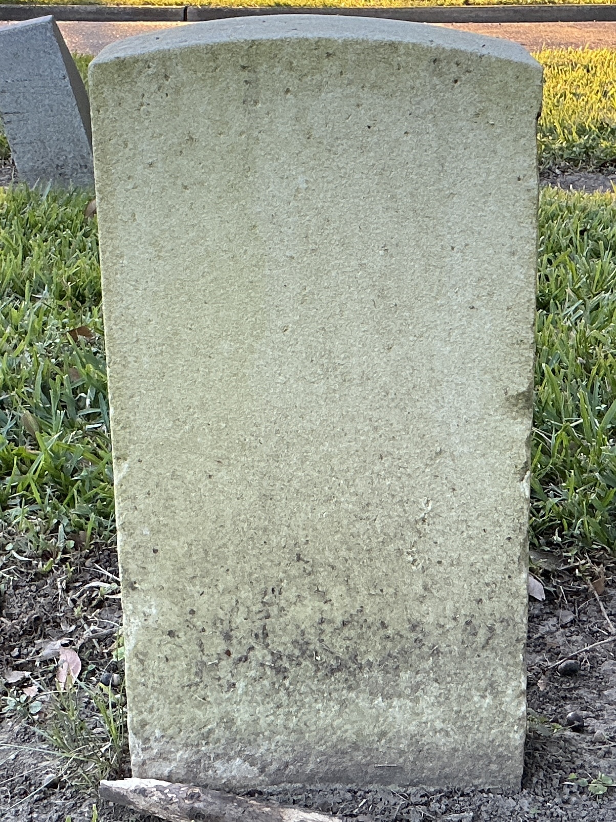 Back of historic upright marble headstone with recessed shield face.