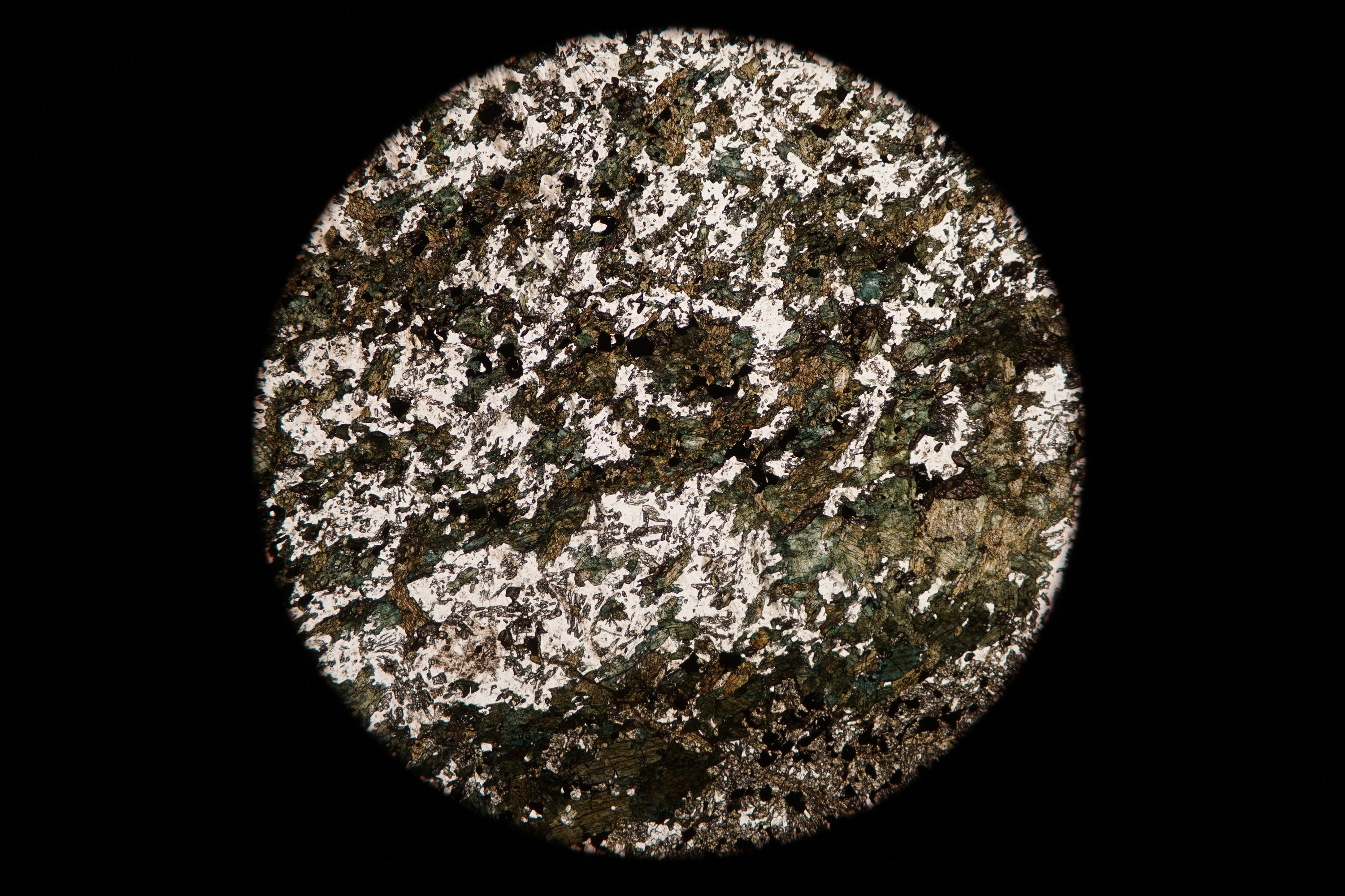 Circular microscopic image of rock structure.