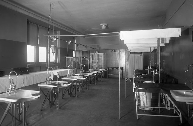 Black & white glass plate negative; structure interior
Government Free Bathhouse interior, genitourinary clinic examining tables/sinks
Protective strips glued along edges