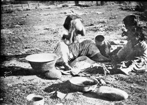 Native American pounding acorns in a mortar. Copied from W.H. Holmes report U.S. National Museum, 1900 plate 12.