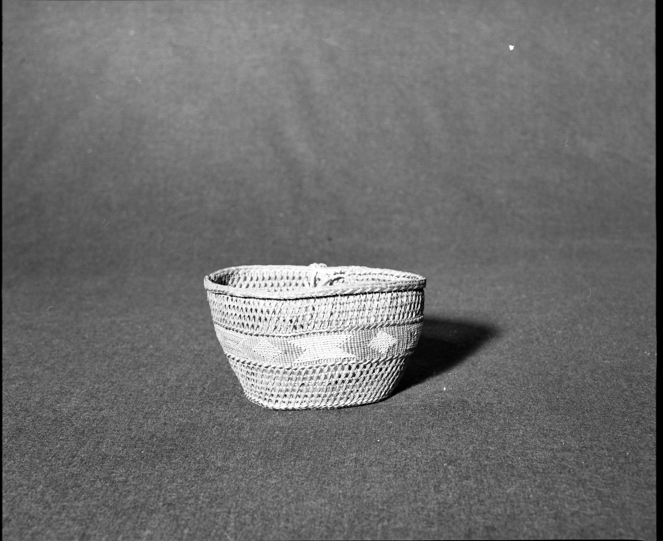 Marie Rozier Collection, Catalog No. 119. Object: Tlingit basket. Dimensions: 6 1/2 x 4 x 3 1/2". Materials: Red cedar, grass. Technology: Stitched piece of wood on base; down to right slant of turns of twining. Collection History: Colt Collection, ca. 1849-1860. Given by M. Long. Alaska. Photographed by Michael Dixon, December 1982. Catalogued by Craig Bates and Barbara Beroza. Yosemite Collections, National Park Service.