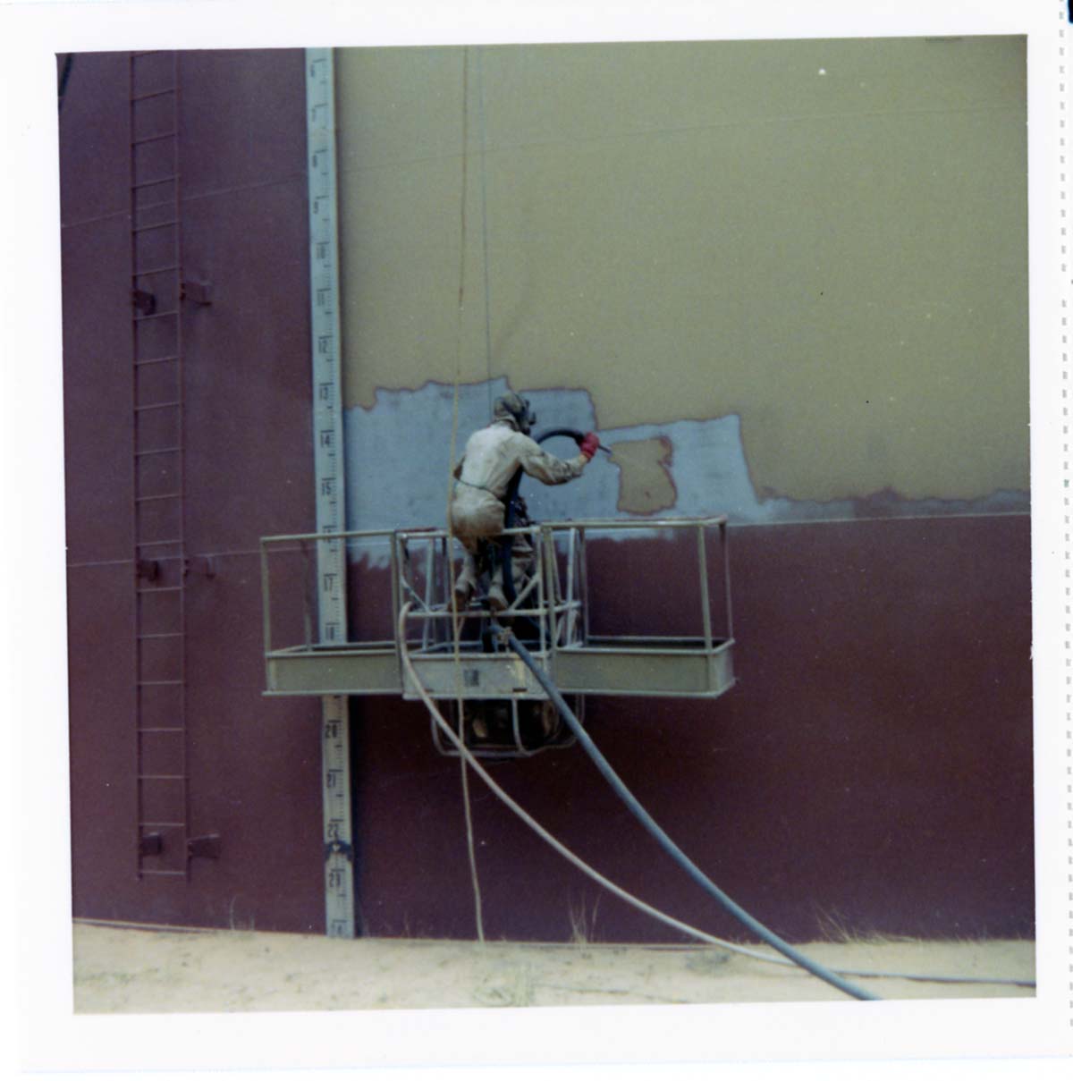 Man repainting the exterior of the million gallon water tank at Birch Creek.