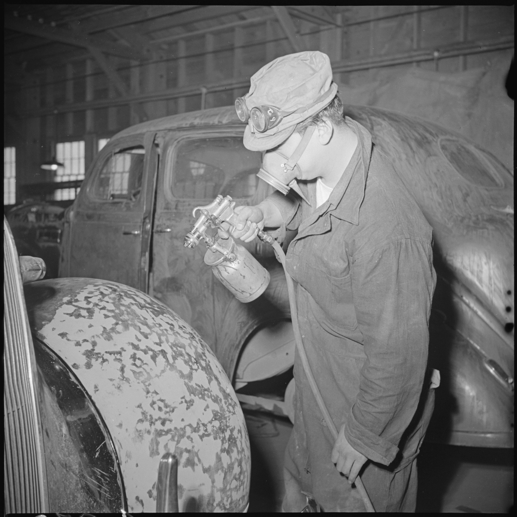 A view in the paint shop in the garage, at this Relocation Center. All repair work on cars, trucks, tractors, and other vehicles, are done by evacuee labor